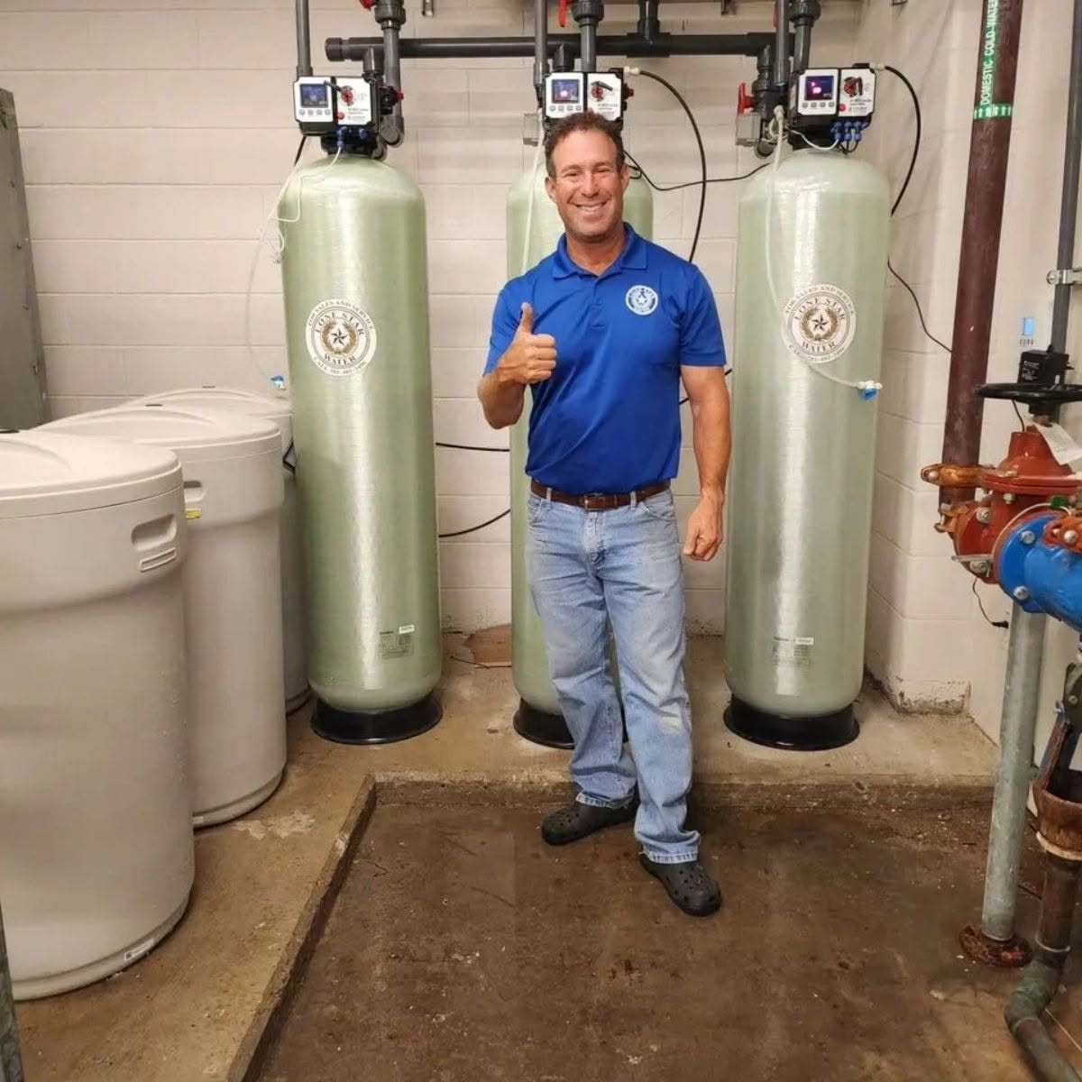Lone Star Water team member standing beside installed treatment tanks