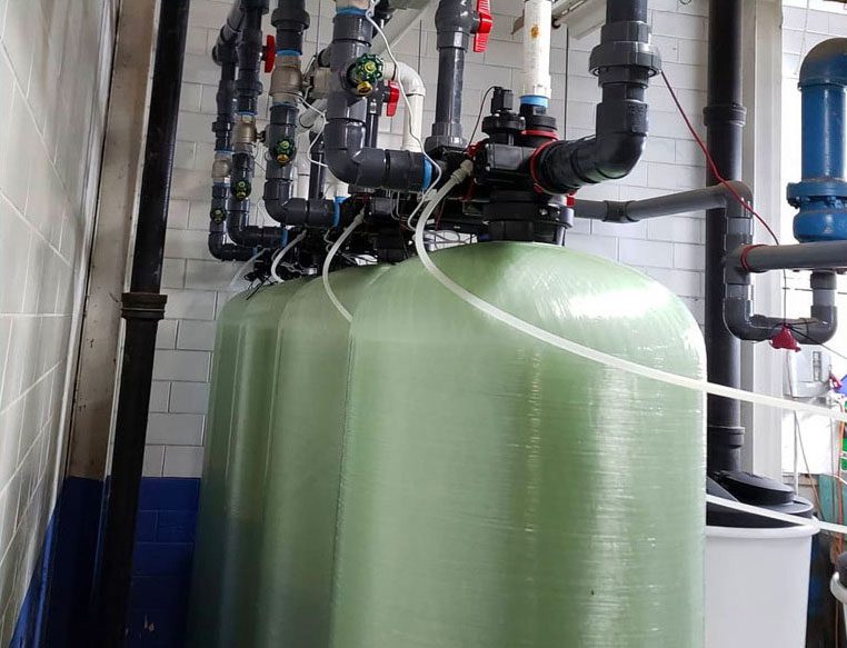 Industrial water filtration system with green tanks.
