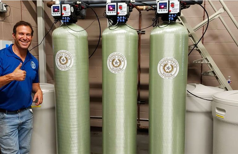 A man standing with three lone star water machines