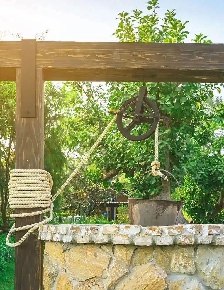 Stone well with pulley and rope.
