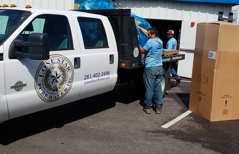 A lLone Star Water van with people unloading a commercial water softener salt delivery