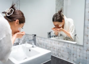 woman washing her face with clean water