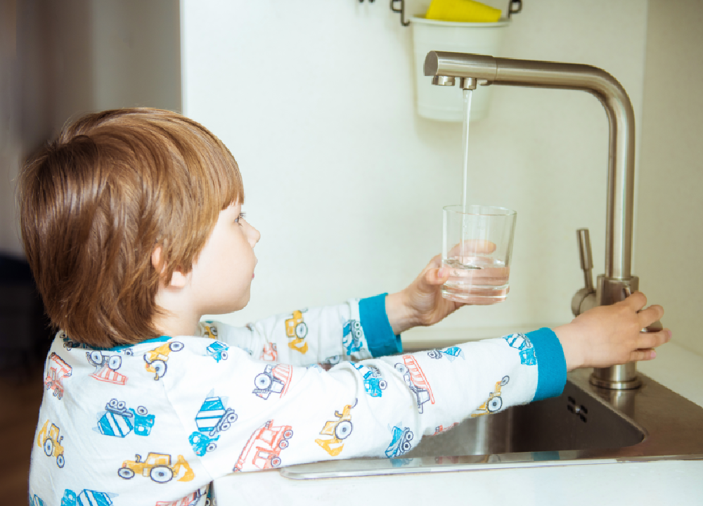 toddler drinking water directly from the faucet with clean, filtered water